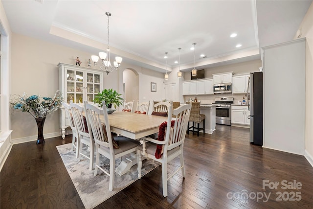 7909 Parknoll Dr, Huntersville, NC 28078 - dining area featuring a tray ceiling, recessed lighting, arched walkways, dark wood-style flooring, and a notable chandelier