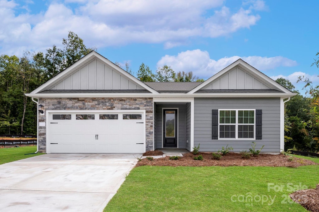 view of front of home featuring an attached garage, board and batten siding, concrete driveway, and a front lawn