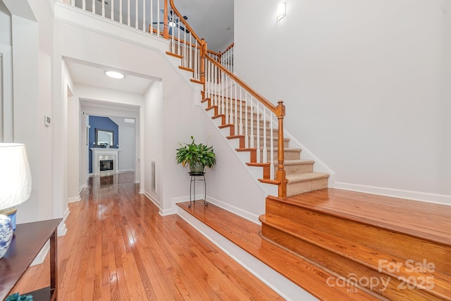 615 Vega St NW, Concord, NC 28027 - foyer entrance with stairs, hardwood / wood-style floors, baseboards, a fireplace, and a high ceiling