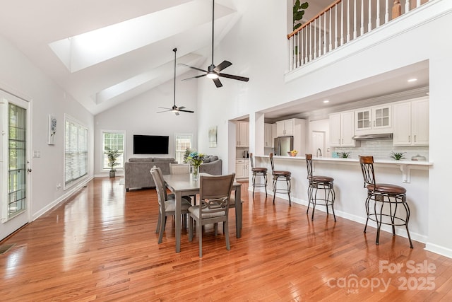 615 Vega St NW, Concord, NC 28027 - dining area with high vaulted ceiling, a ceiling fan, light wood-style floors, baseboards, and a skylight