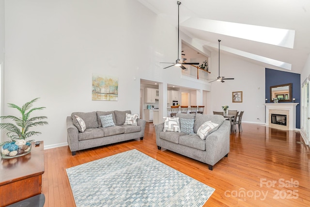 615 Vega St NW, Concord, NC 28027 - living area with ceiling fan, light wood finished floors, high vaulted ceiling, baseboards, and a fireplace