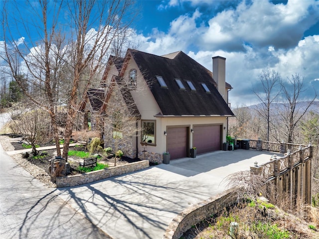 view of front of property featuring roof with shingles, concrete driveway, a chimney, fence, and an attached garage