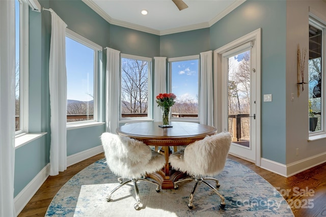 dining space featuring baseboards, ornamental molding, and wood finished floors