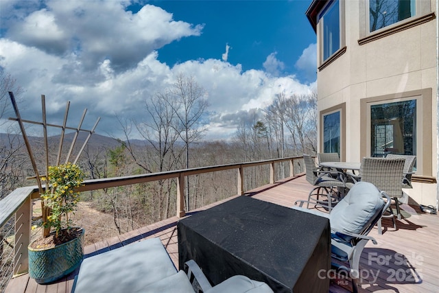 deck with a mountain view and outdoor dining space