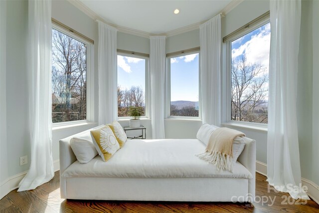 bedroom featuring baseboards, wood finished floors, and crown molding
