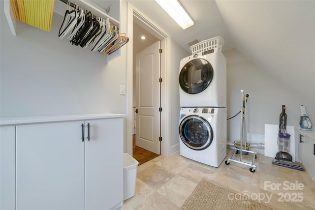clothes washing area with stacked washer / dryer and laundry area