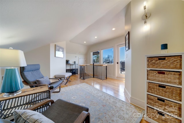 living area with an upstairs landing, vaulted ceiling, recessed lighting, light wood-type flooring, and baseboards