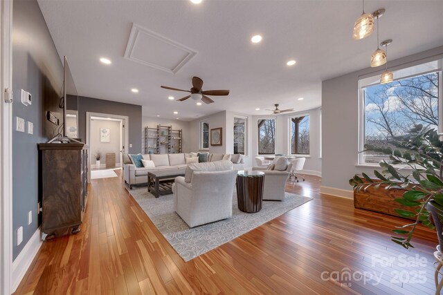 living area with baseboards, ceiling fan, recessed lighting, and wood-type flooring