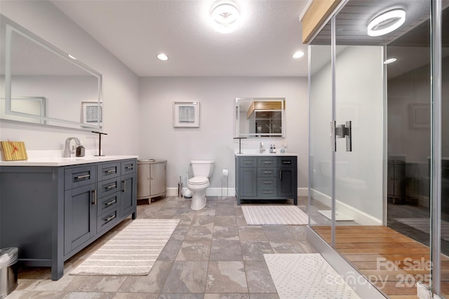 bathroom featuring vanity, recessed lighting, toilet, baseboards, and a walk in shower
