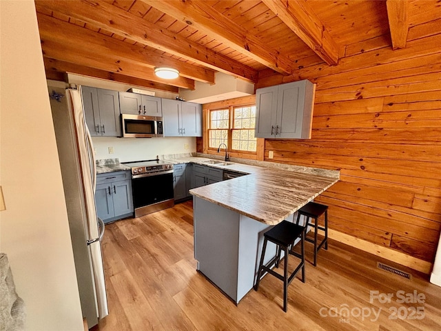 522 Woodgate Dr, Bostic, NC 28018 - kitchen featuring appliances with stainless steel finishes, gray cabinets, a peninsula, a sink, and a kitchen bar