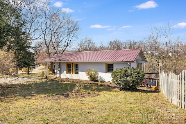 323 Emma Rd, Asheville, NC 28806 - view of side of home with metal roof, stucco siding, fence, and a yard