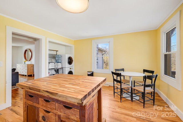 323 Emma Rd, Asheville, NC 28806 - kitchen featuring wooden counters, stacked washer / dryer, light wood-style floors, and crown molding