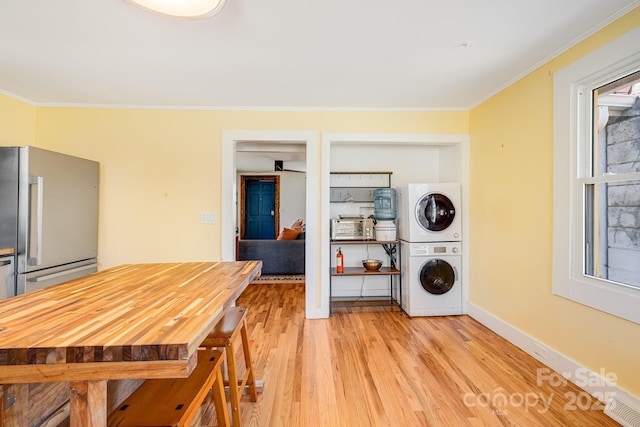 323 Emma Rd, Asheville, NC 28806 - dining space with stacked washer / dryer, plenty of natural light, crown molding, and light wood-type flooring
