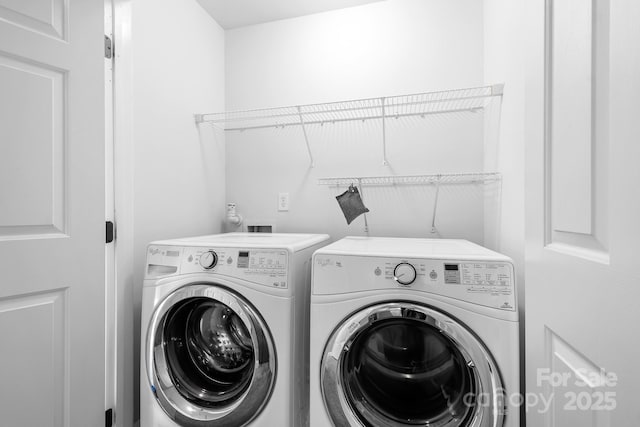 clothes washing area with separate washer and dryer and laundry area