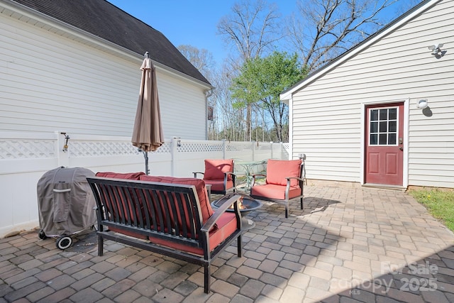 view of patio featuring grilling area, fence, and an outdoor hangout area