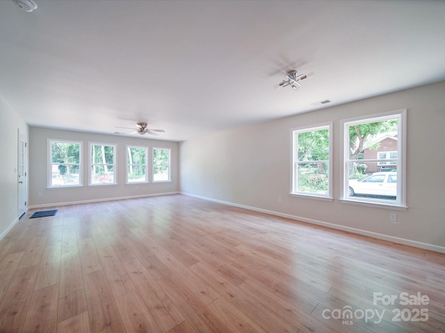 unfurnished living room with baseboards, ceiling fan, and light wood-style flooring