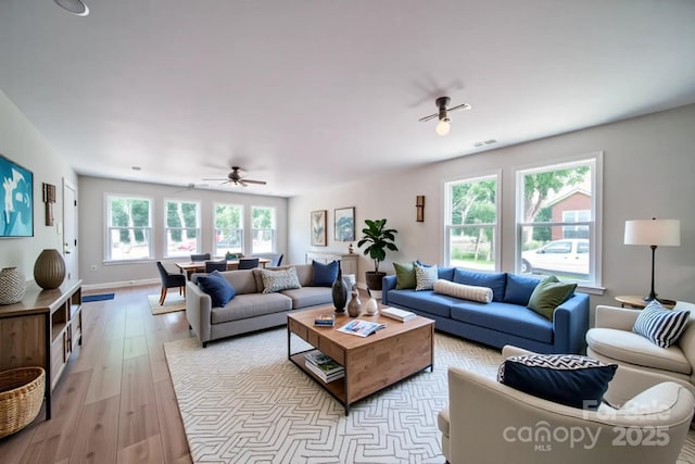 living area with a ceiling fan and light wood-style flooring