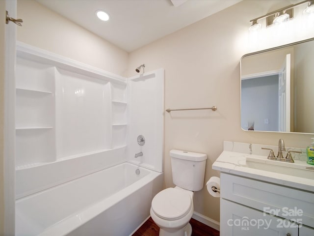 full bath featuring toilet, vanity, bathtub / shower combination, wood finished floors, and baseboards