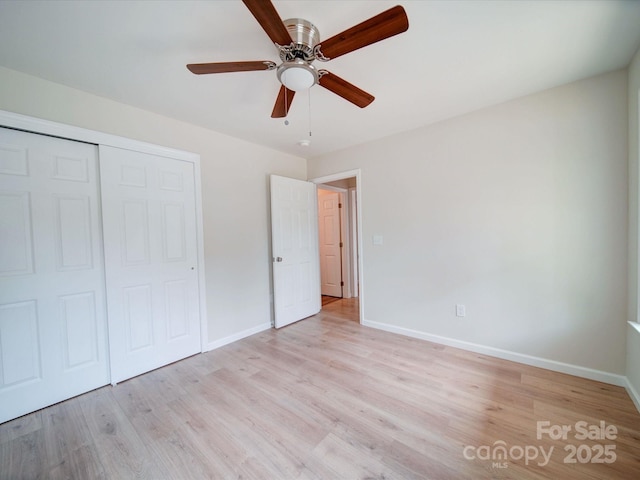 unfurnished bedroom with light wood-style floors, baseboards, a closet, and ceiling fan