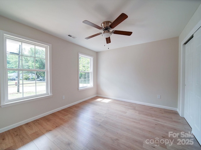 unfurnished room featuring light wood-style floors, a ceiling fan, and baseboards