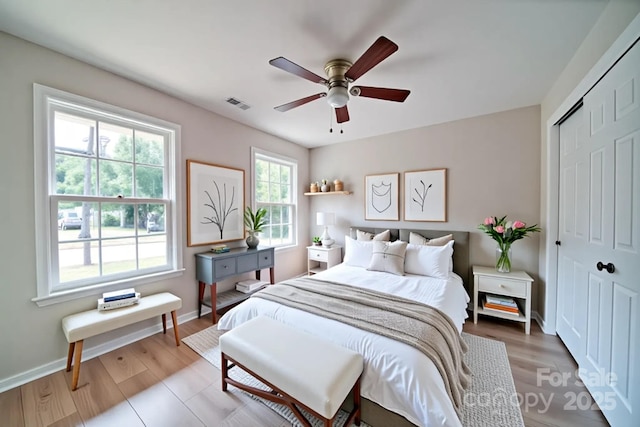 bedroom featuring a closet, baseboards, a ceiling fan, and wood finished floors