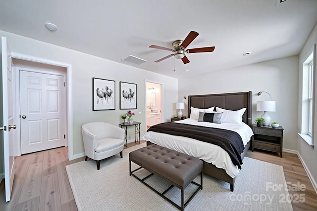bedroom with light wood-style floors, ensuite bathroom, baseboards, and a ceiling fan