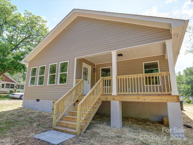 rear view of house featuring crawl space and a porch