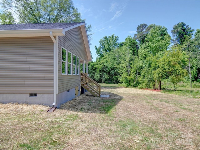 view of side of home with crawl space and stairs