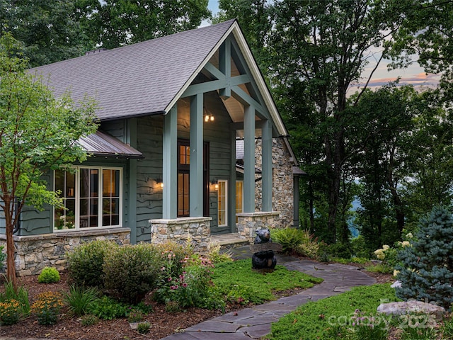 view of front of house with stone siding and a shingled roof
