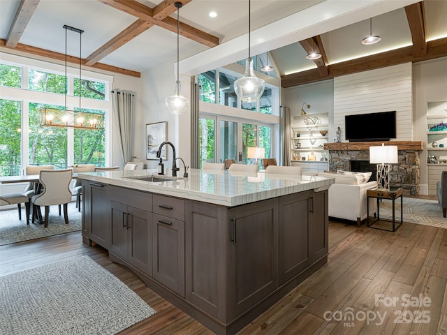 kitchen with dark wood-style flooring, beamed ceiling, and a sink