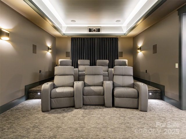 carpeted home theater featuring a raised ceiling and visible vents