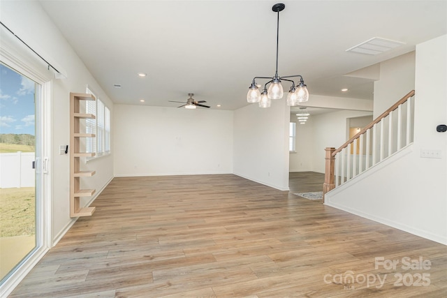 interior space featuring recessed lighting, light wood-style flooring, and ceiling fan with notable chandelier