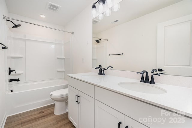 full bath featuring a sink, visible vents, and wood finished floors