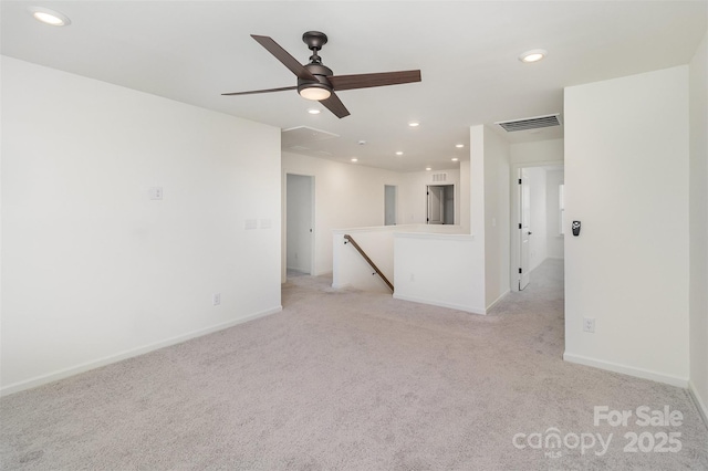 empty room with visible vents, baseboards, recessed lighting, and light colored carpet