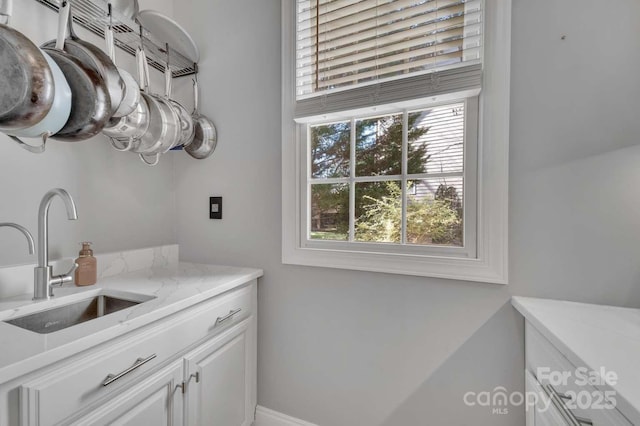 clothes washing area with a sink and cabinet space