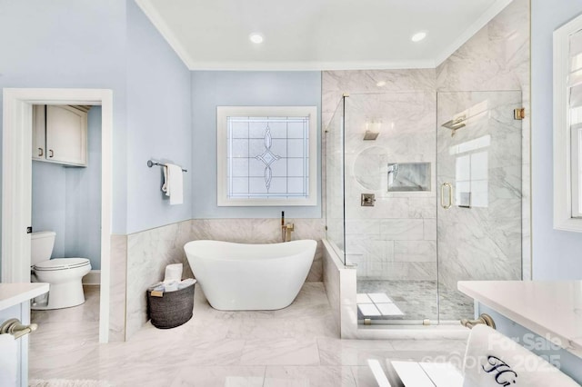 bathroom with a stall shower, a freestanding tub, marble finish floor, toilet, and ornamental molding