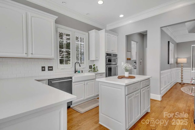 4536 Rustling Woods Dr, Denver, NC 28037 - kitchen with appliances with stainless steel finishes, white cabinets, crown molding, light wood-type flooring, and light countertops