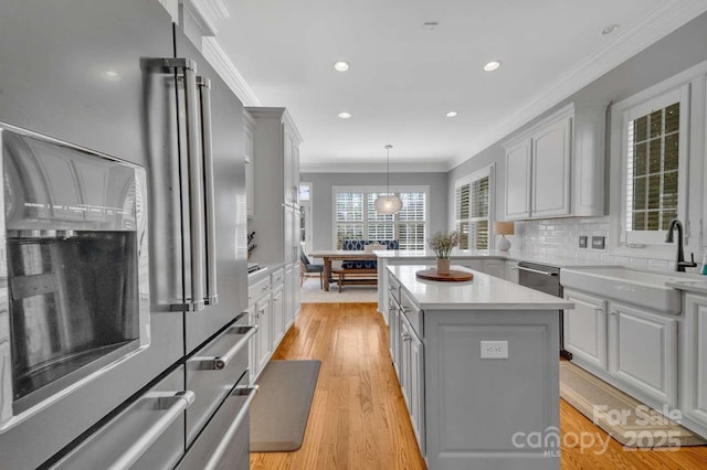 4536 Rustling Woods Dr, Denver, NC 28037 - kitchen with stainless steel appliances, a sink, light countertops, ornamental molding, and a center island
