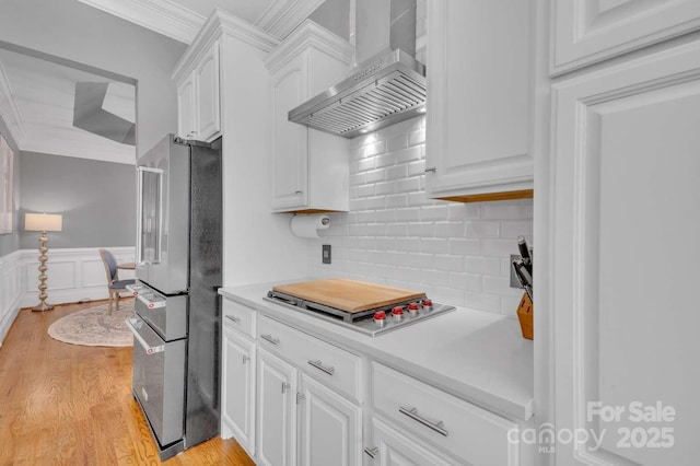 4536 Rustling Woods Dr, Denver, NC 28037 - kitchen with wall chimney range hood, freestanding refrigerator, ornamental molding, white cabinets, and light countertops