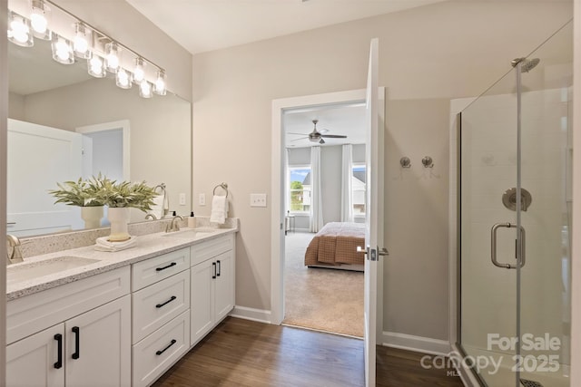 full bathroom with wood finished floors, a sink, ceiling fan, and a stall shower