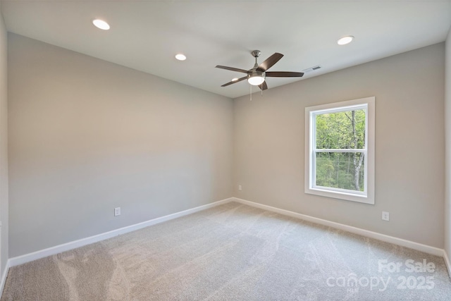 empty room with light colored carpet, baseboards, and visible vents