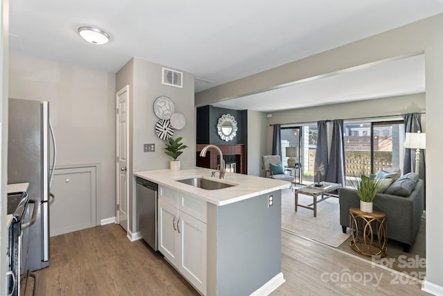 419 W 8th St, Charlotte, NC 28202 - kitchen featuring visible vents, a sink, open floor plan, a peninsula, and appliances with stainless steel finishes