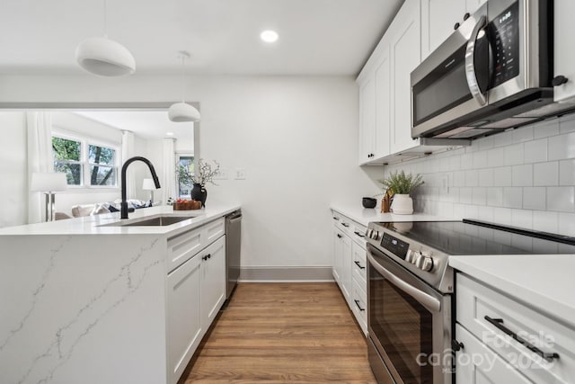 1749 Archdale Dr, Charlotte, NC 28210 - kitchen featuring appliances with stainless steel finishes, backsplash, recessed lighting, white cabinetry, and light wood-style flooring