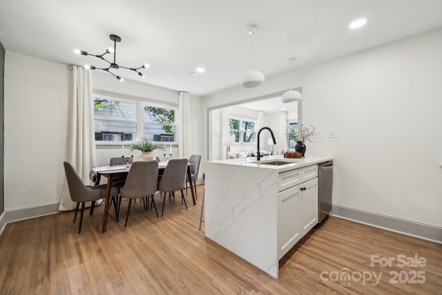 1749 Archdale Dr, Charlotte, NC 28210 - kitchen featuring light stone countertops, light wood-style flooring, a chandelier, a peninsula, and white cabinets