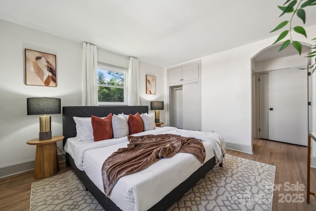 1749 Archdale Dr, Charlotte, NC 28210 - bedroom with wood finished floors, arched walkways, and a closet