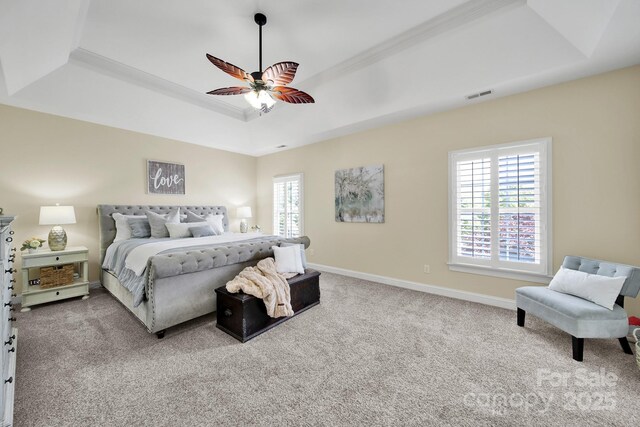 bedroom with carpet flooring, baseboards, visible vents, and a raised ceiling