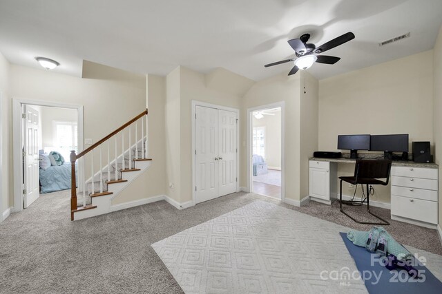 carpeted office space featuring a healthy amount of sunlight, baseboards, a ceiling fan, and visible vents