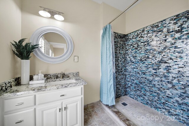 bathroom featuring vanity and tiled shower