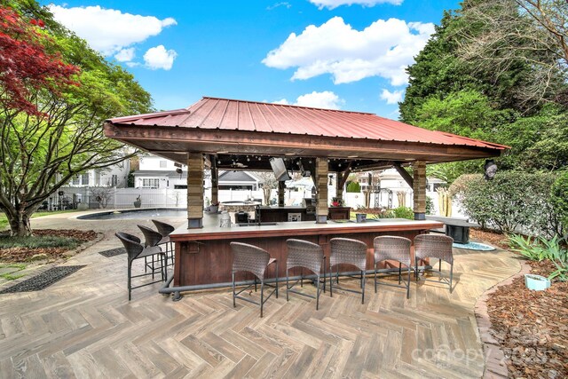 view of patio / terrace with a gazebo, outdoor wet bar, and fence