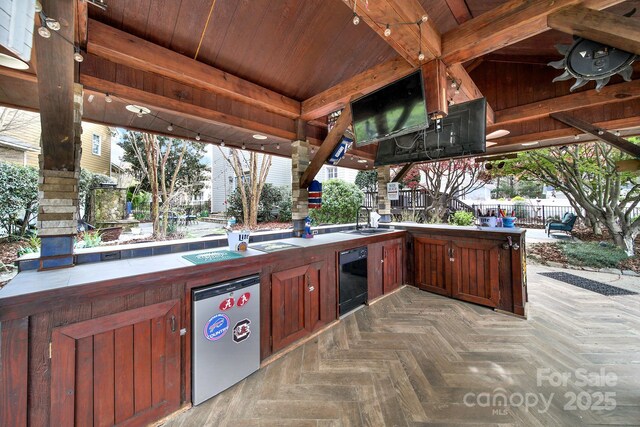view of patio with a sink, an outdoor kitchen, and fence